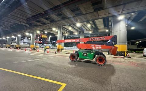 Dingli BT20 boom lift working at height under a covered terminal at night in Johor