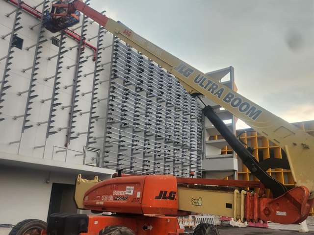 JLG 1250AJP boom lift working on a building facade